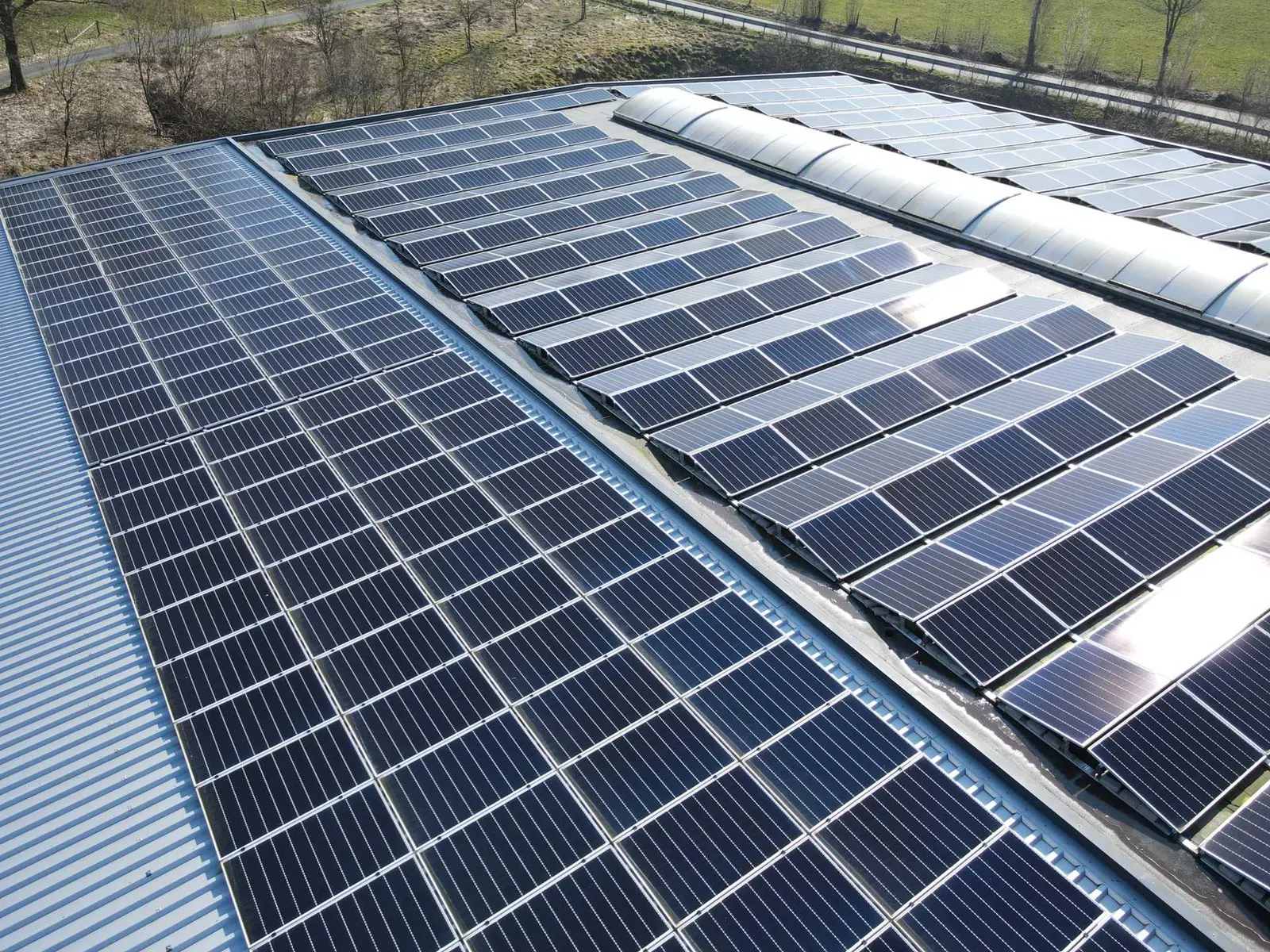 PV-Module auf dem Dach einer Industriehalle mit Lichtband